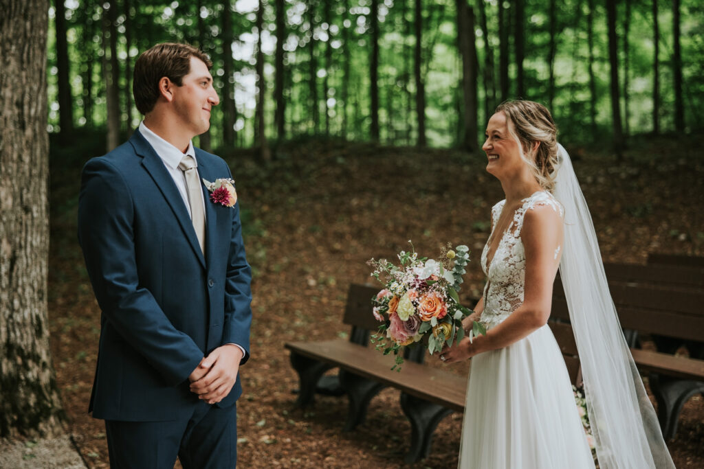 Bride and groom sharing a heartfelt first look under old trees, Traverse City Wedding Photography.