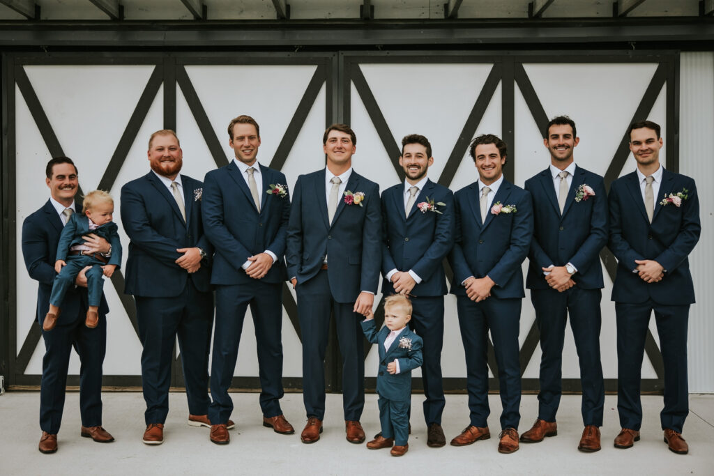 Groom laughing with groomsmen in Vera Wang menswear, Traverse City wedding.