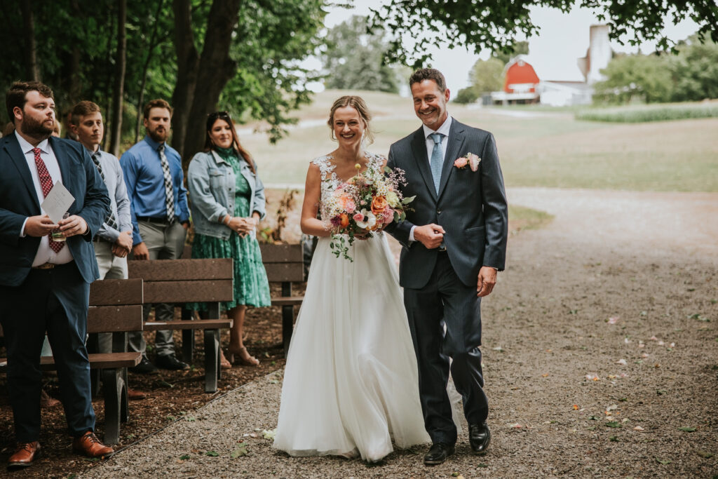 Bride smiling radiantly as she walks down the aisle, Traverse City Wedding Photography.