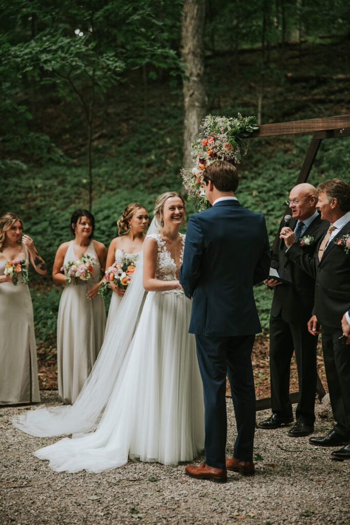 Sun breaking through clouds over woodland wedding ceremony, Traverse City Wedding Photography.