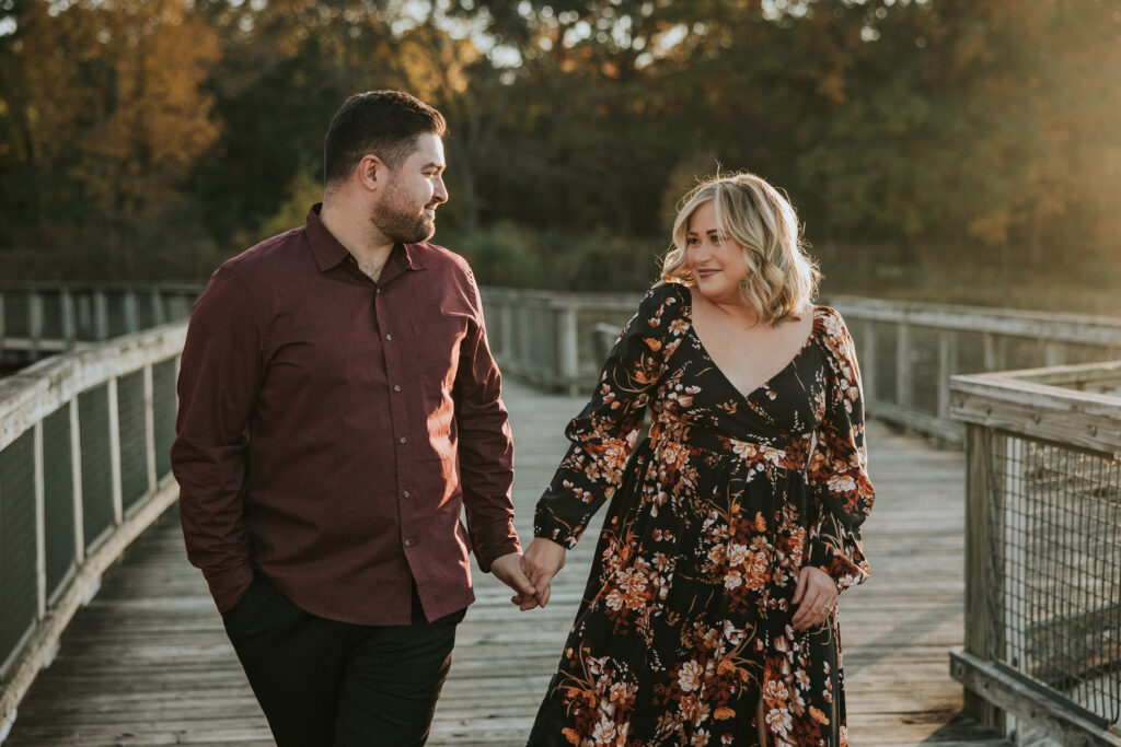 Bride and groom walking along the boardwalk at their Kensington Metropark Engagement Session