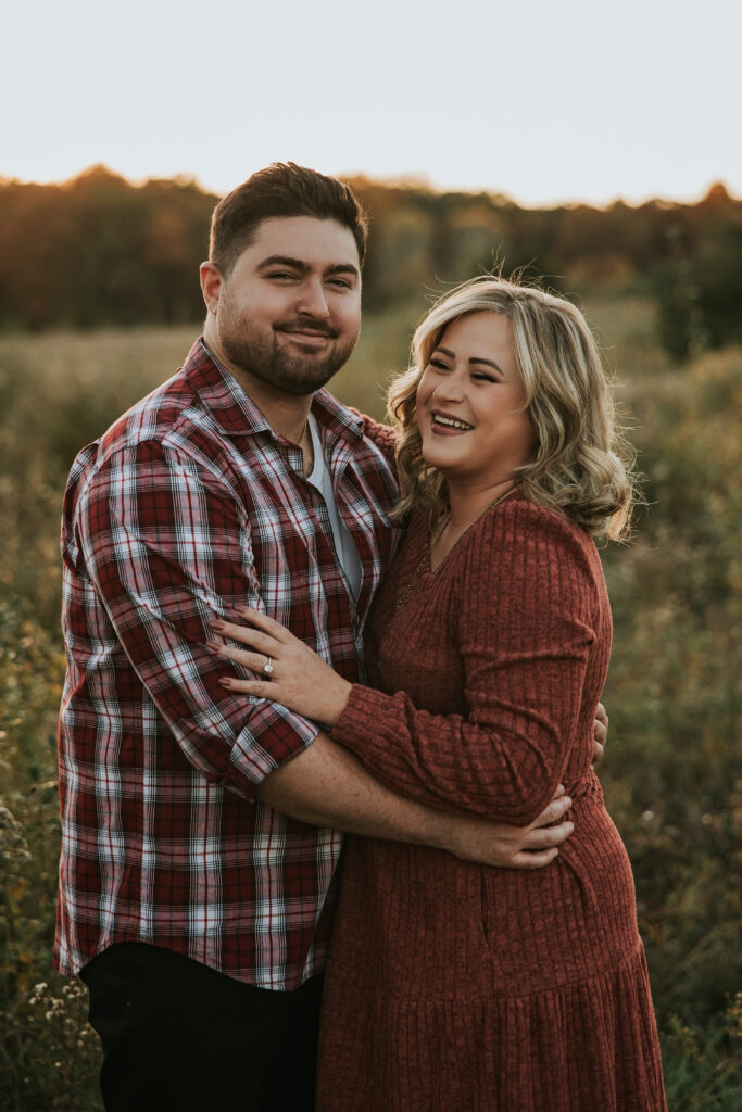 Bride and groom laughing in front of the sunset at their Kensington Metropark Engagement Session