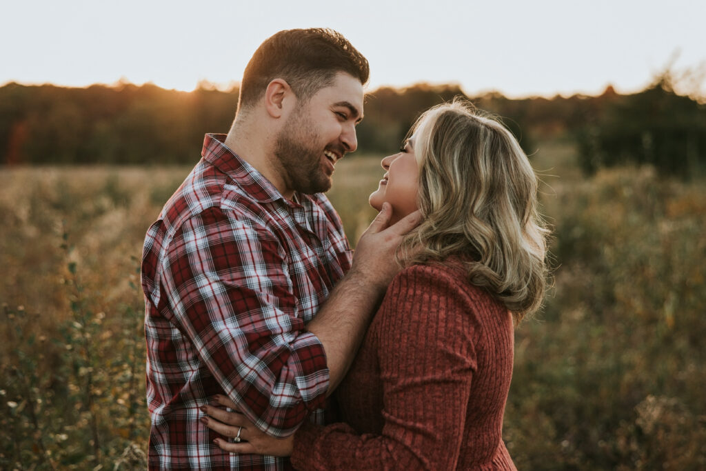 Kensington Metropark Engagement Session in sunset lit field with bride and groom looking at one another