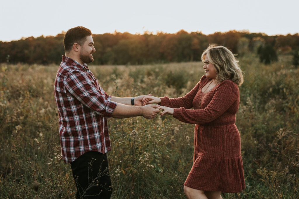 Bride and groom dancing in a field during their Kensington Metropark Engagement Session